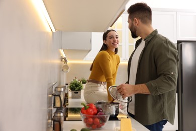 Lovely young couple cooking together in kitchen