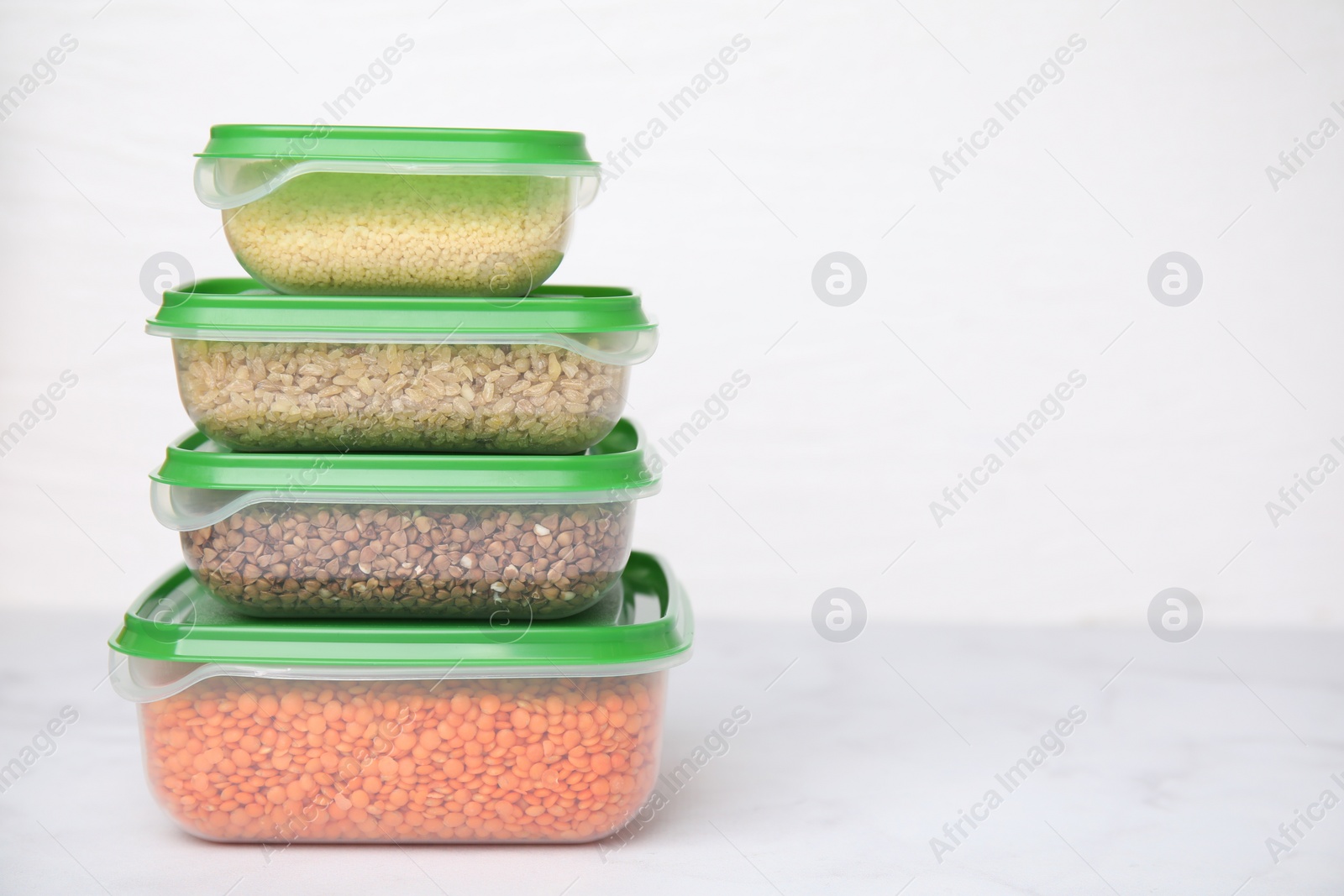 Photo of Plastic containers filled with food products on white table. Space for text