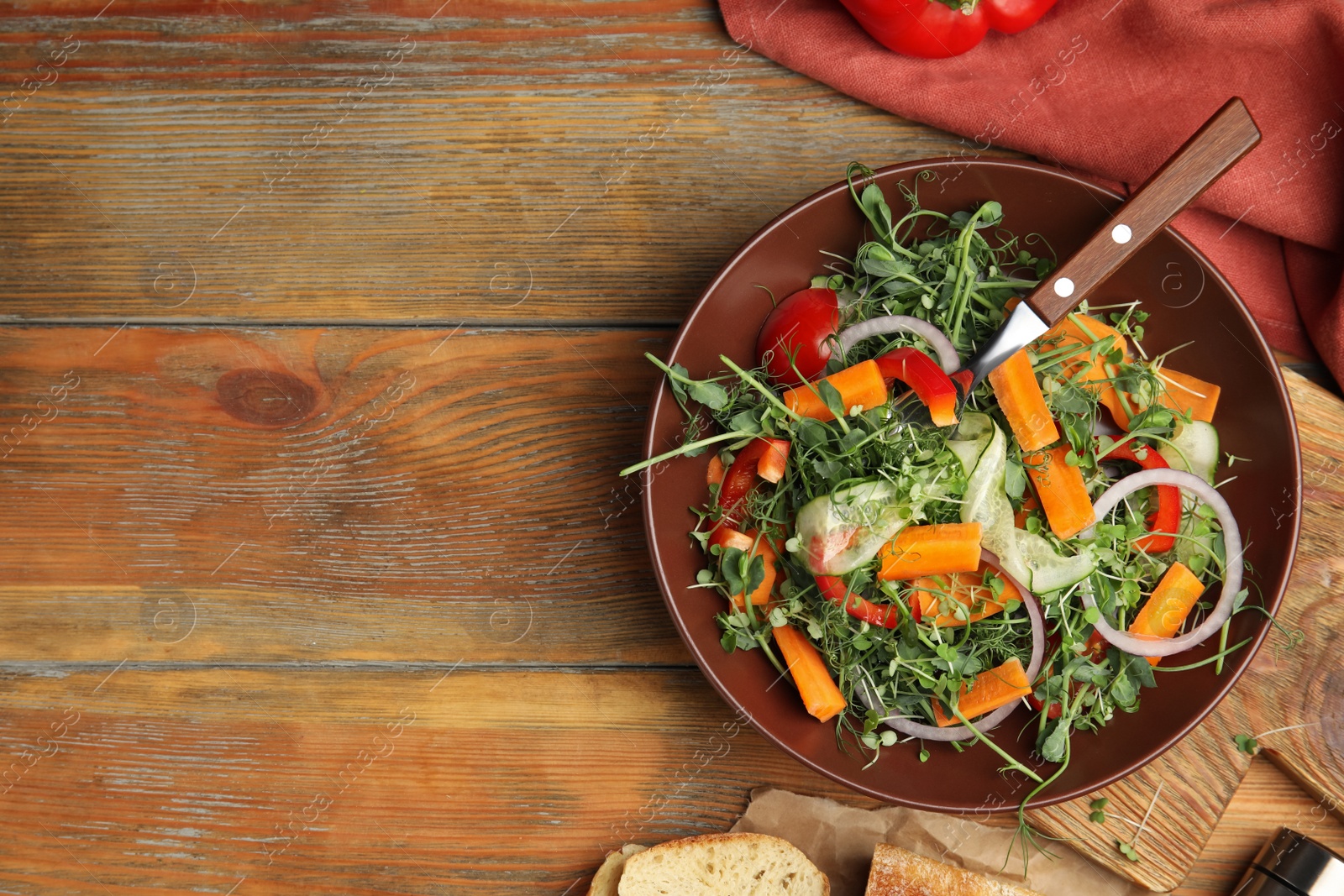 Photo of Delicious vegetable salad with microgreen served on wooden table, flat lay. Space for text