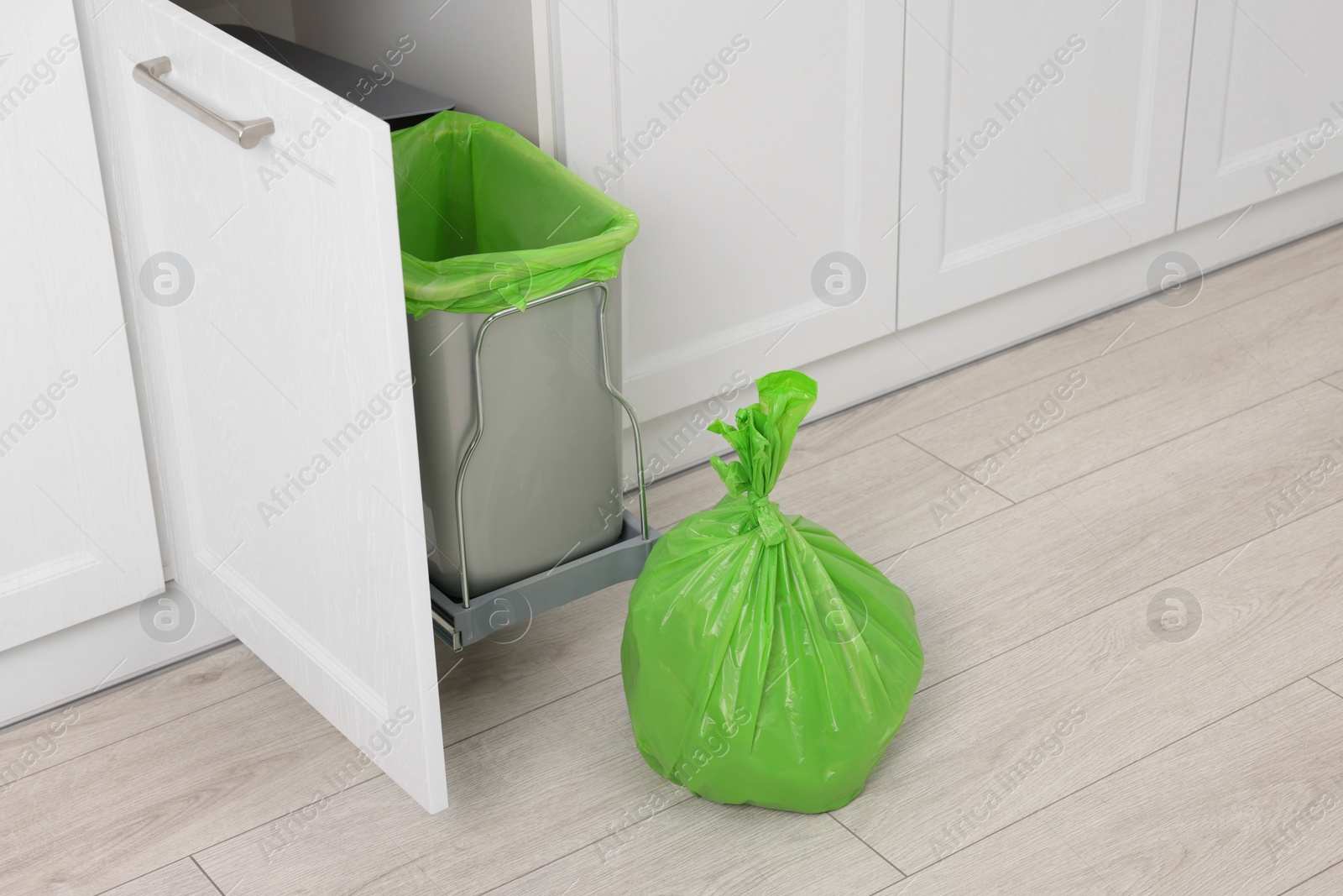 Photo of Plastic garbage bag and trash can indoors. Space for text