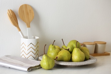 Photo of Plate with fresh ripe pears on white table