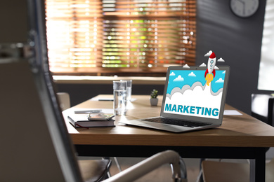 Image of Digital marketing concept. Modern laptop on wooden table in office
