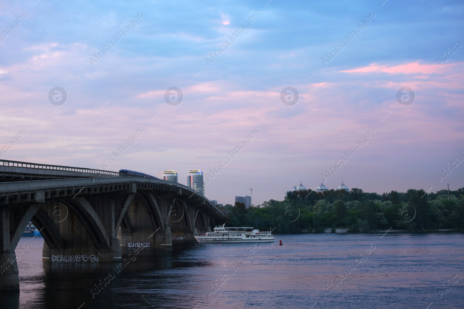 Photo of KYIV, UKRAINE - MAY 23, 2019: Beautiful view of Metro bridge over Dnipro river in evening