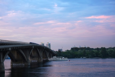 Photo of KYIV, UKRAINE - MAY 23, 2019: Beautiful view of Metro bridge over Dnipro river in evening