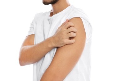 Photo of Young man scratching shoulder on white background, closeup. Annoying itch