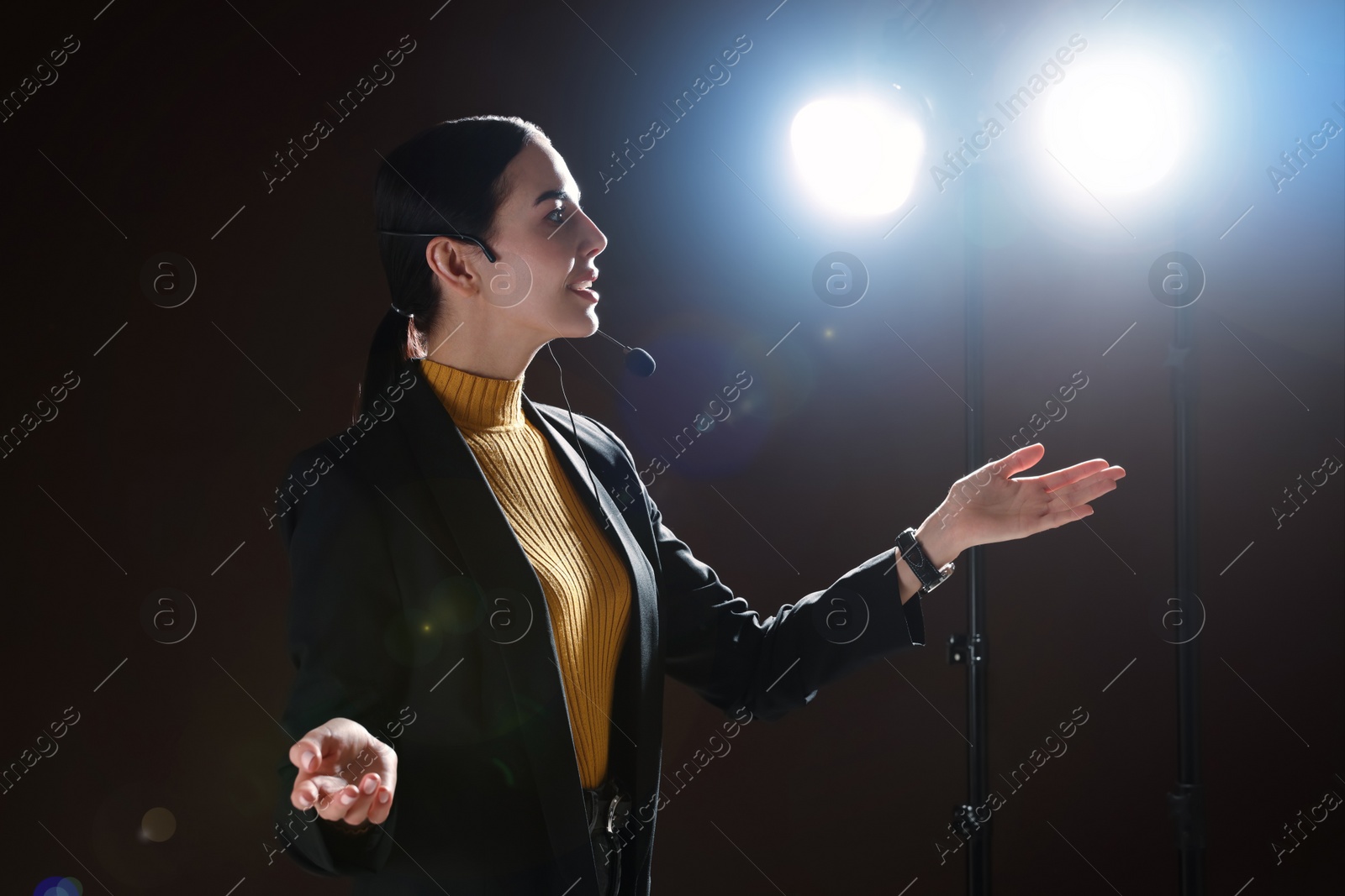 Photo of Motivational speaker with headset performing on stage