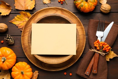 Top view of seasonal table setting with pumpkins and autumn leaves on wooden background, space for text. Thanksgiving Day