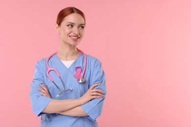 Photo of Mammologist with pink ribbon on color background, space for text. Breast cancer awareness