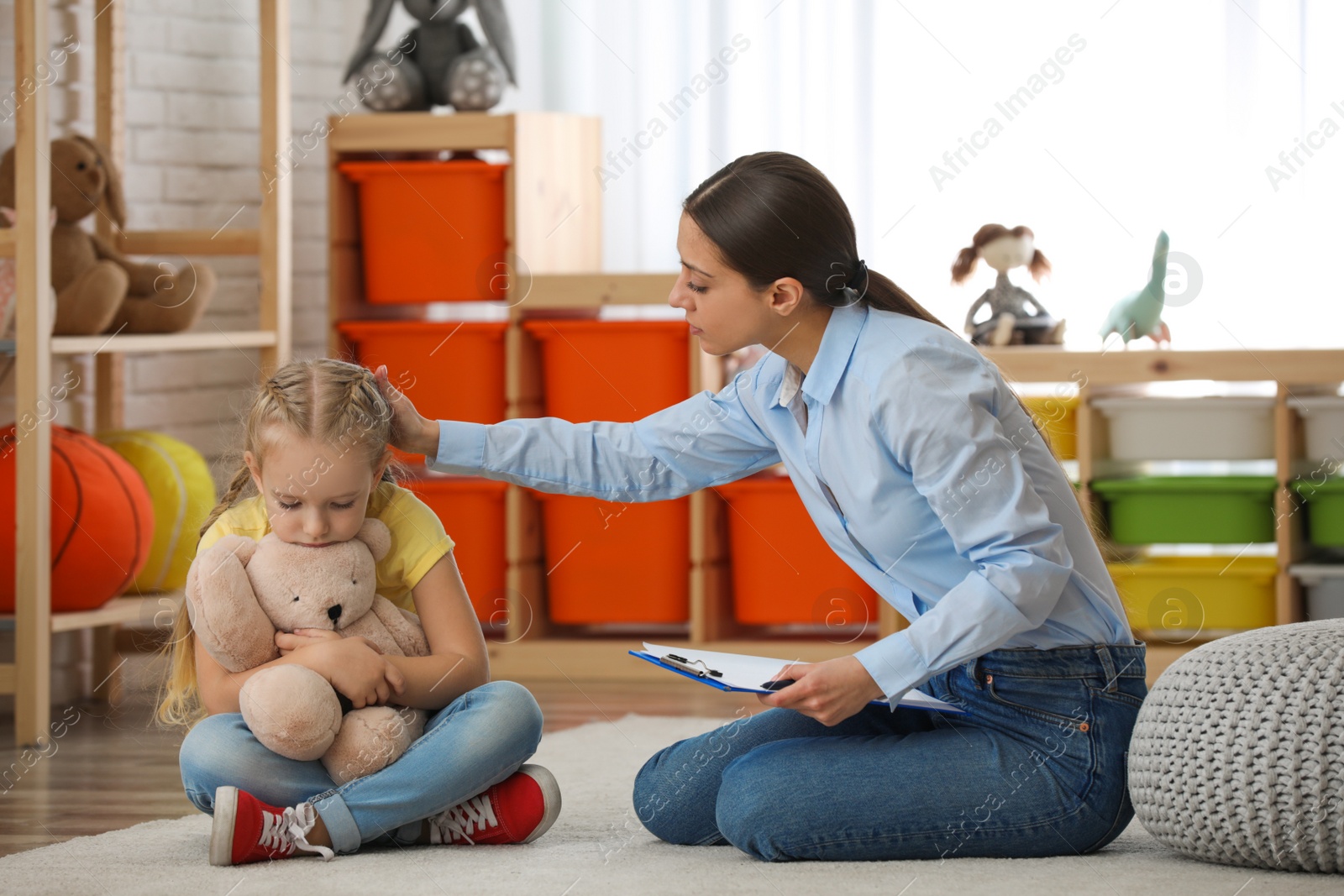 Photo of Child psychotherapist working with little girl in office