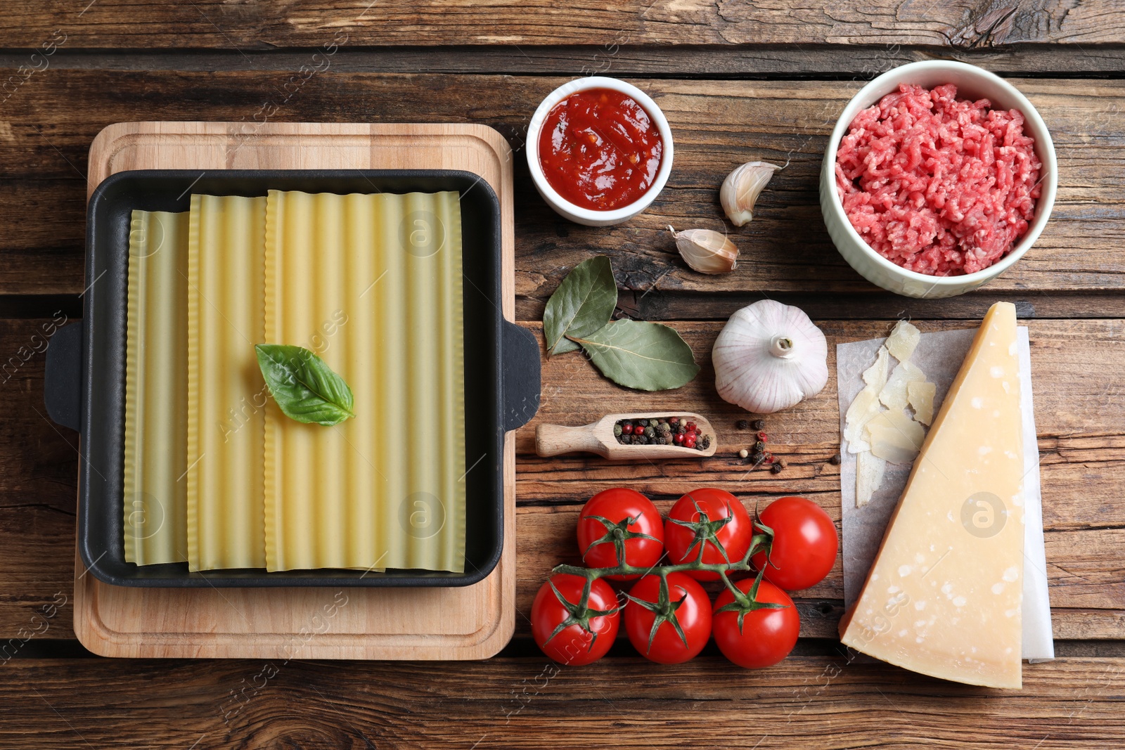 Photo of Fresh ingredients for lasagna on wooden table, flat lay