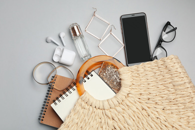 Photo of Stylish knitted woman's bag with accessories on light grey background, flat lay