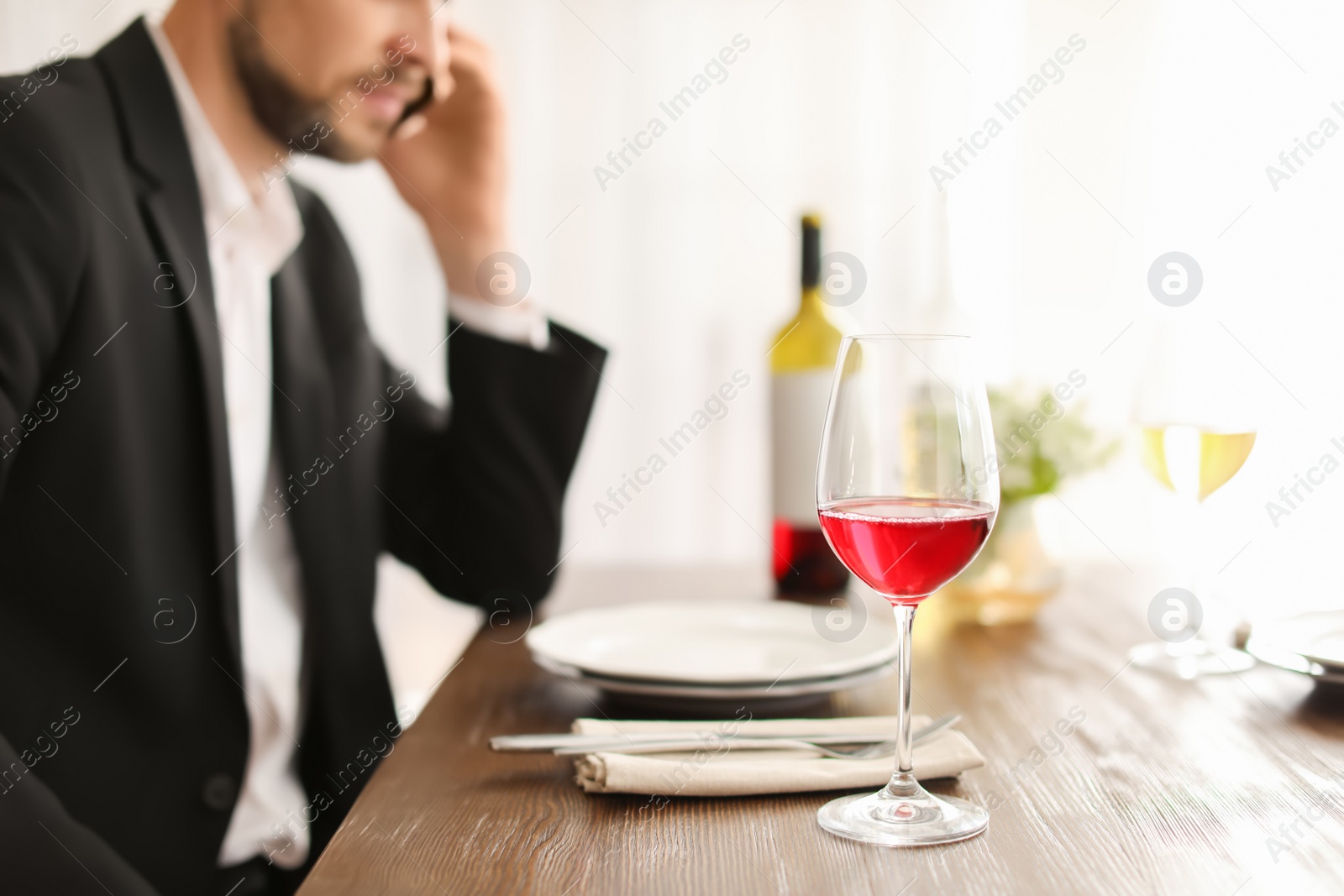 Photo of Man with glass of wine at table in restaurant