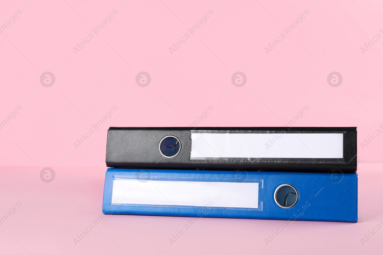 Photo of Bright hardcover office folders on pink background