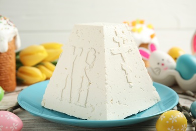 Photo of Traditional cottage cheese Easter paskha and dyed eggs on white wooden table, closeup