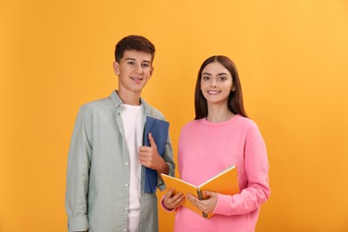 Photo of Teenage students with stationery on yellow background