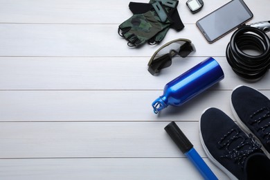 Flat lay composition with different cycling accessories on white wooden background, space for text