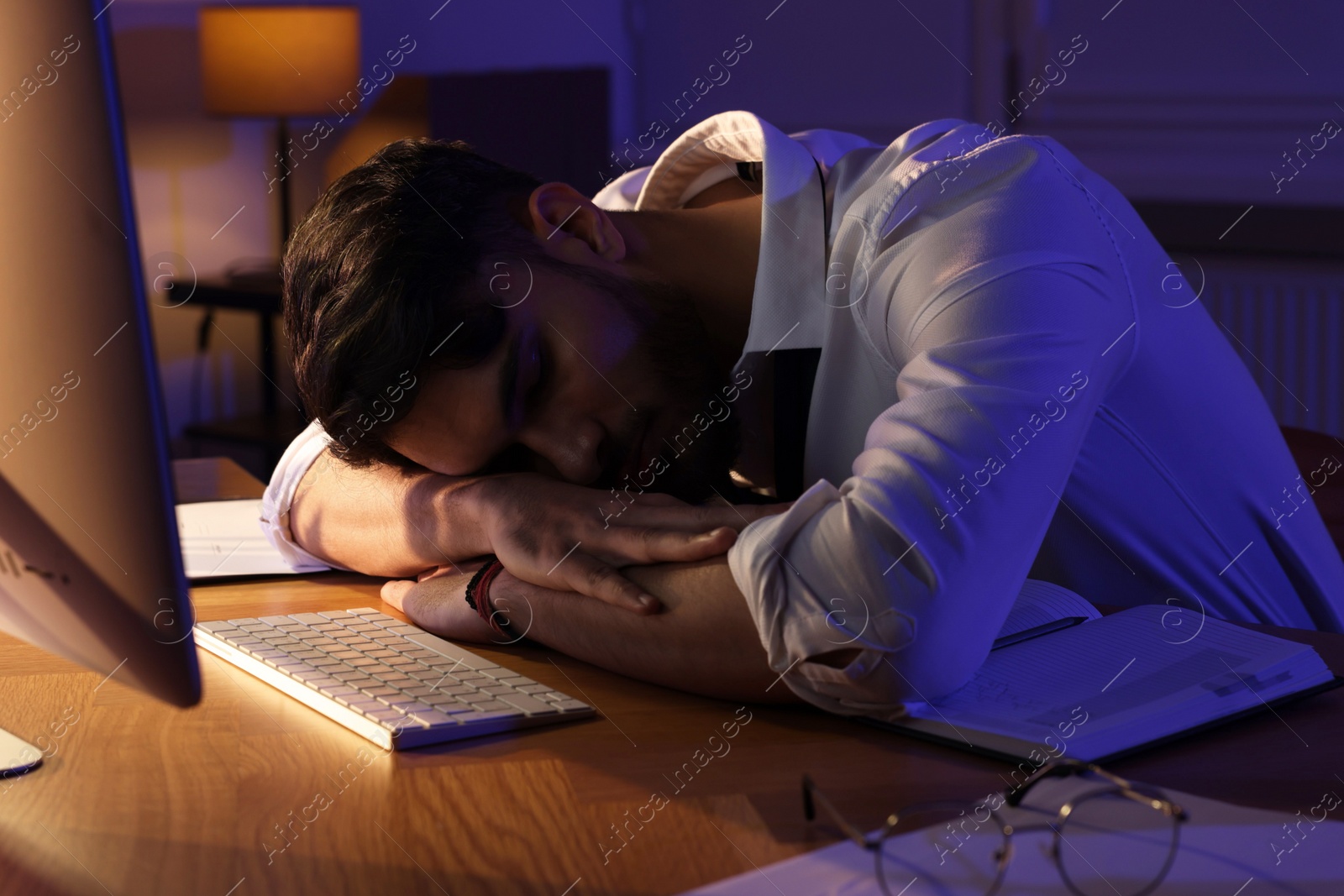 Photo of Tired man fell asleep at workplace in office