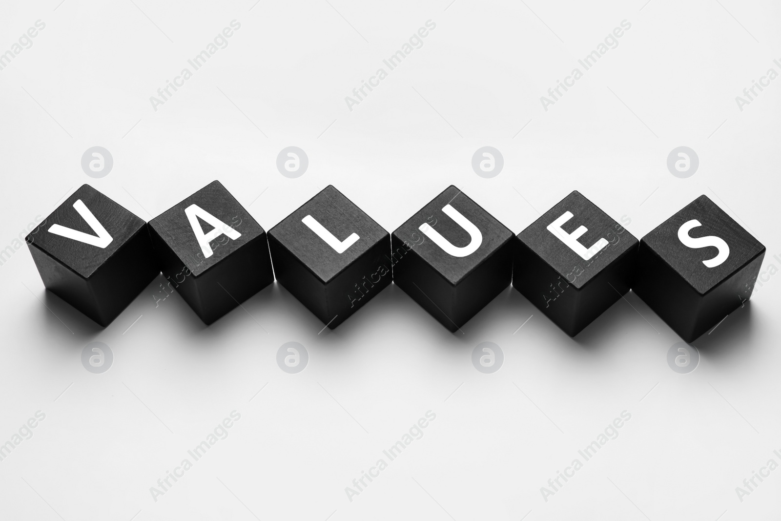 Photo of Black wooden cubes with word VALUES on white background