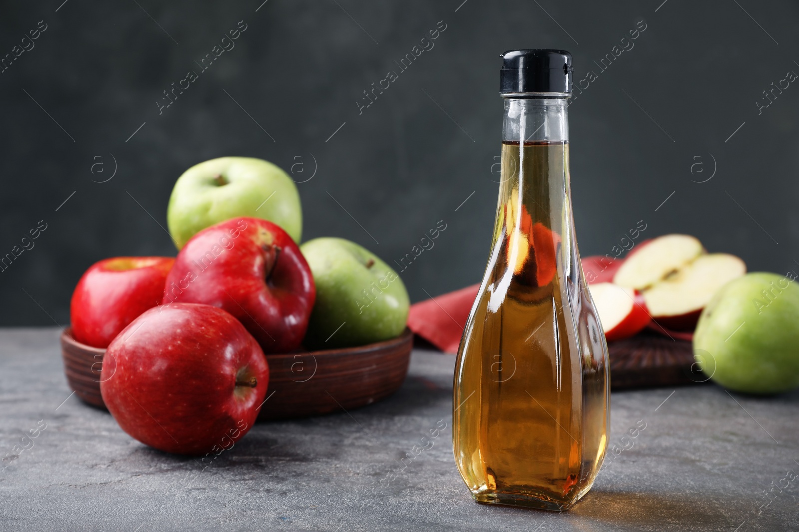 Photo of Composition with bottle of apple vinegar on table. Space for text