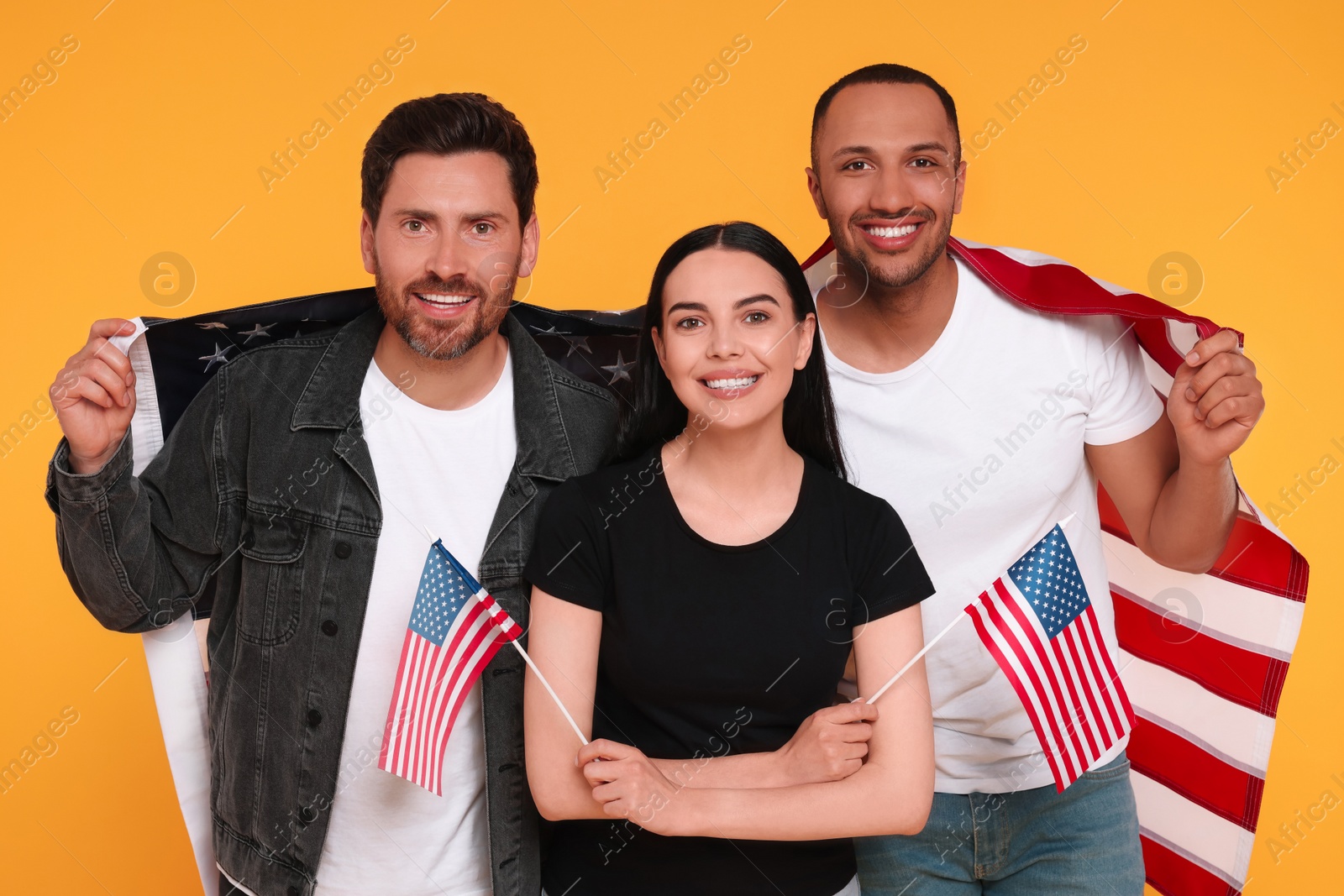 Photo of 4th of July - Independence Day of USA. Happy friends with American flags on yellow background