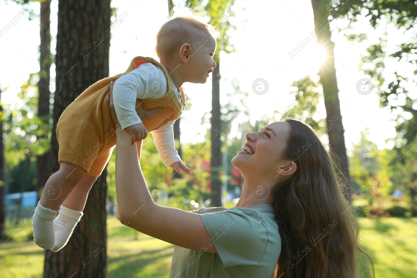 Photo of Beautiful mother with her cute daughter spending time together in park on summer day