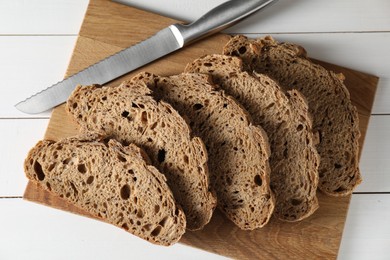 Freshly baked cut sourdough bread on white wooden table, top view