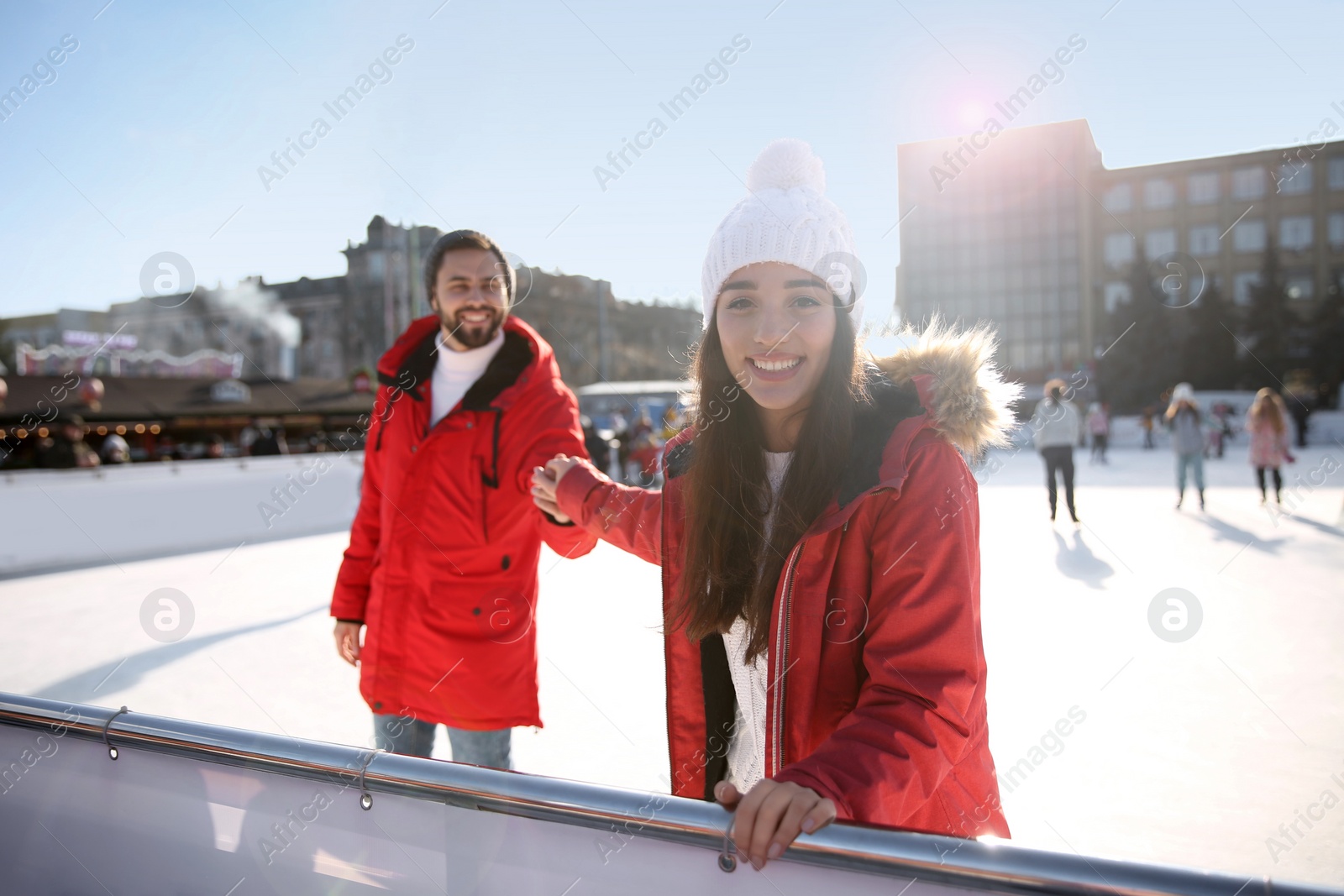 Image of Lovely couple spending time together at outdoor ice skating rink