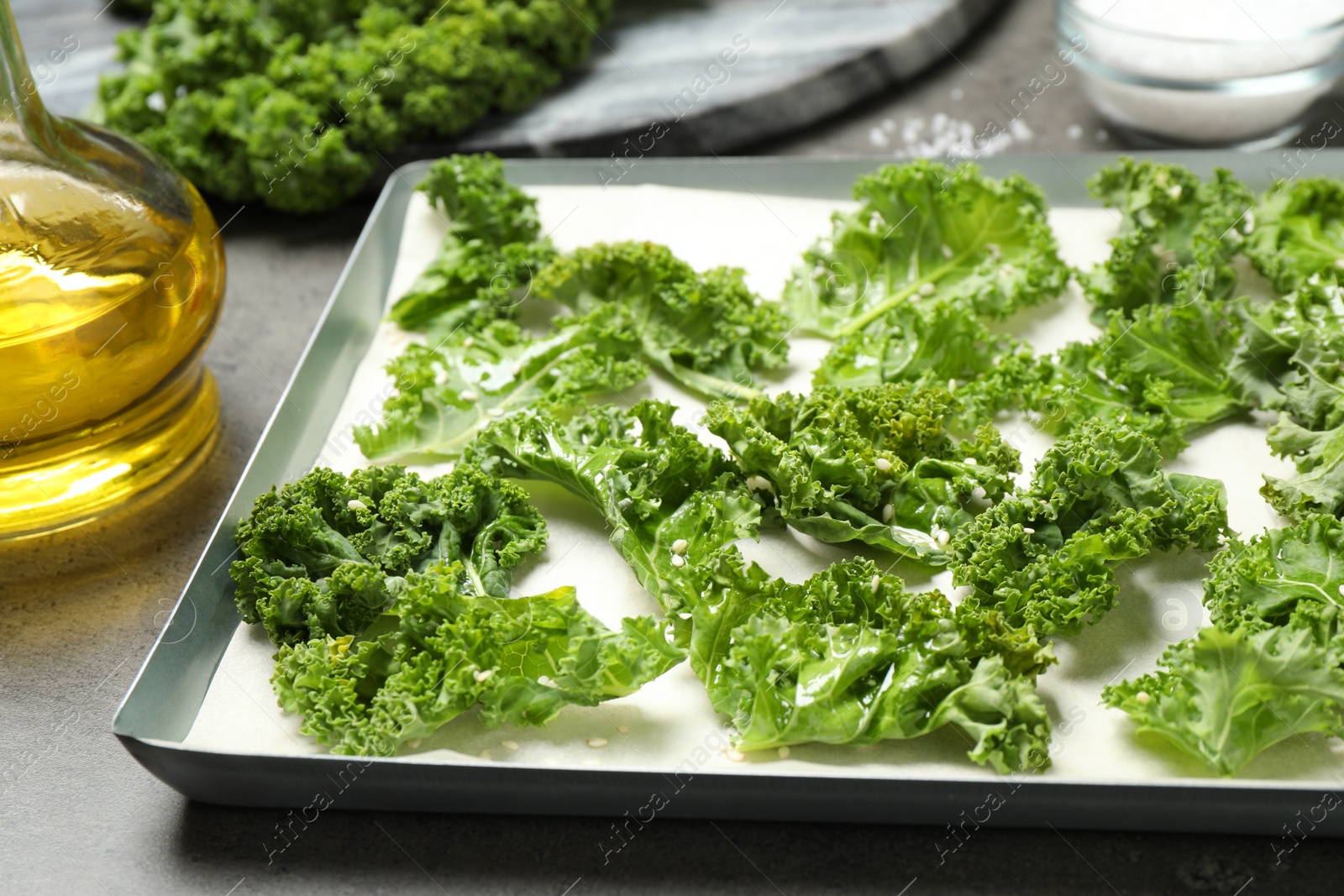 Photo of Raw cabbage leaves on grey table, closeup. Preparing kale chips