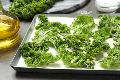 Raw cabbage leaves on grey table, closeup. Preparing kale chips