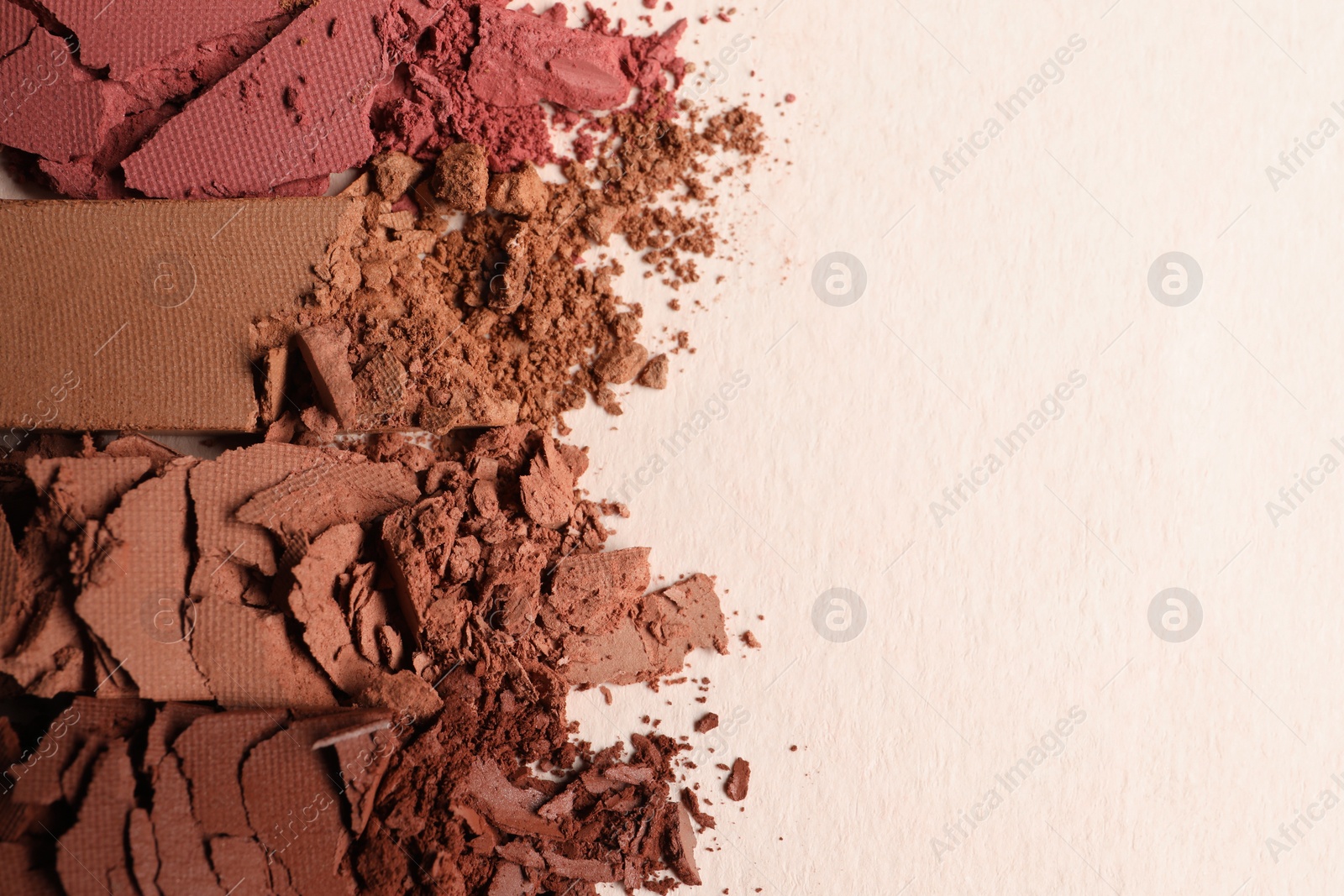 Photo of Different crushed eye shadows on beige background, flat lay. Space for text