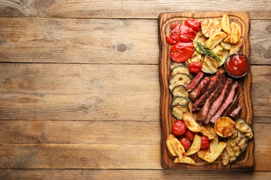 Delicious grilled beef with vegetables, rosemary and tomato sauce on wooden table, top view. Space for text