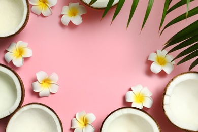 Photo of Frame with fresh coconut halves on pink background, flat lay. Space for text