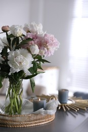 Photo of Bouquet of beautiful peony flowers on table indoors