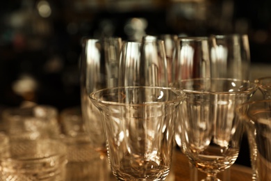 Different empty clean glasses in bar, closeup