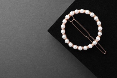 Photo of Elegant pearl hair clip on black background, top view. Space for text