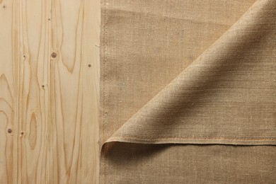 Burlap fabric on wooden table, top view