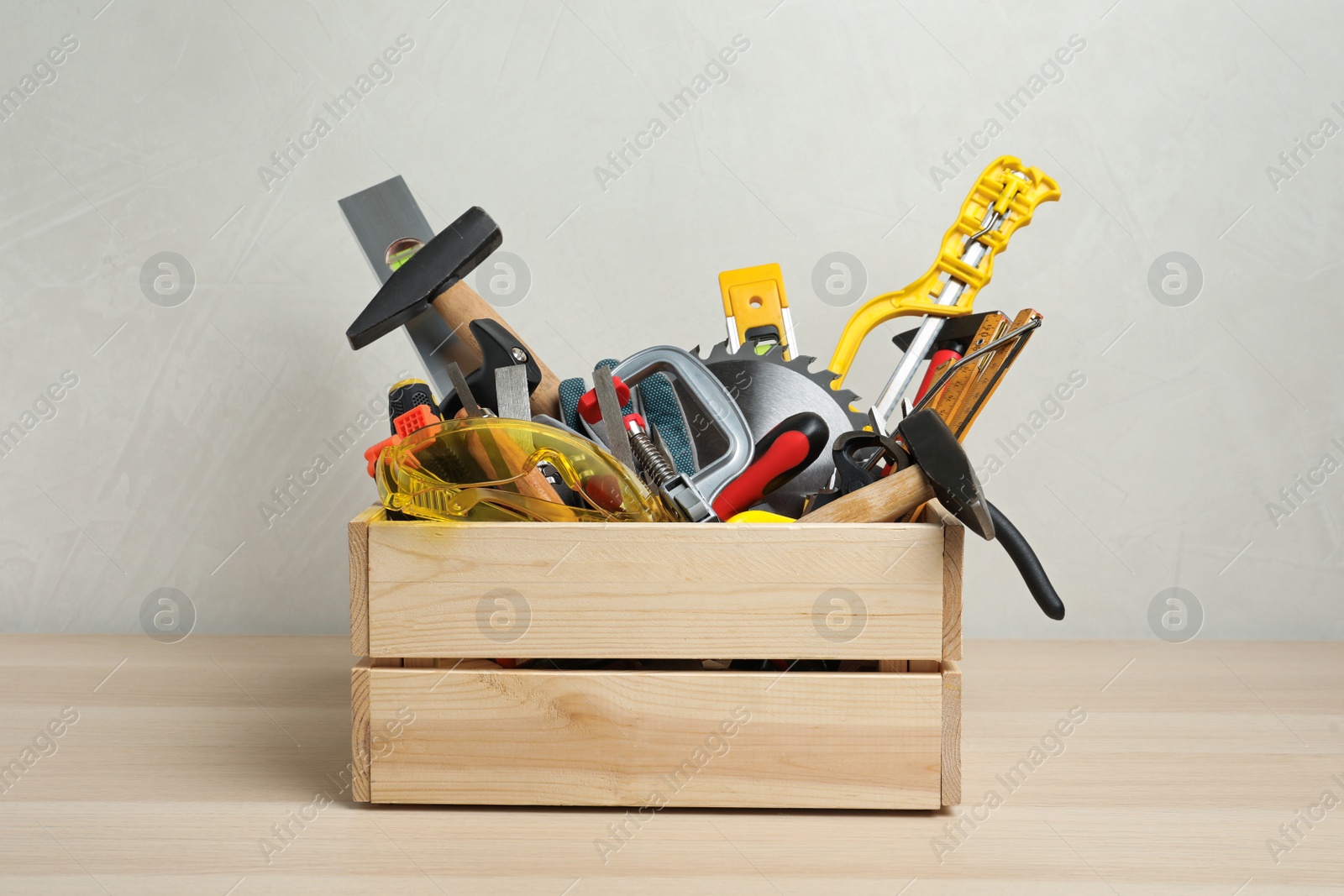 Photo of Crate with different carpenter's tools on wooden table