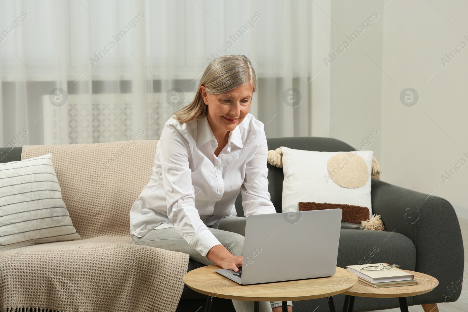 Photo of Beautiful senior woman using laptop at home