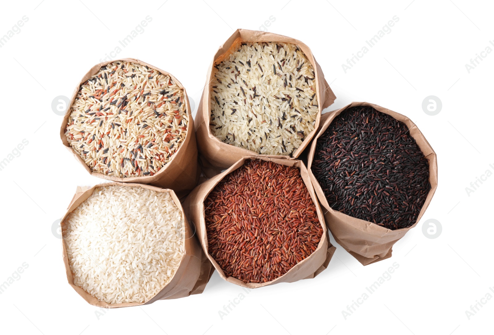 Photo of Brown and polished rice in paper bags on white background, top view