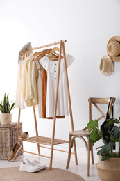 Photo of Rack with stylish women's clothes indoors. Interior design