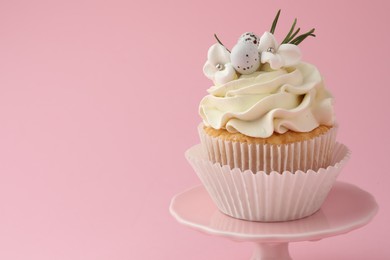 Tasty Easter cupcake with vanilla cream on pink background, space for text