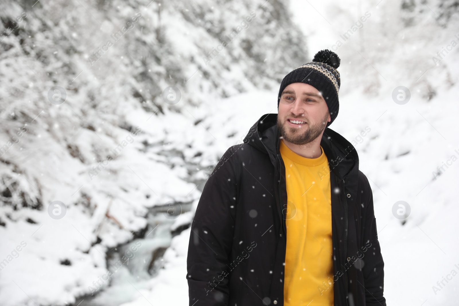 Photo of Handsome man wearing warm clothes outdoors on snowy day. Winter vacation