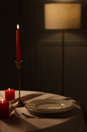 Photo of Elegant table setting with burning candles in restaurant