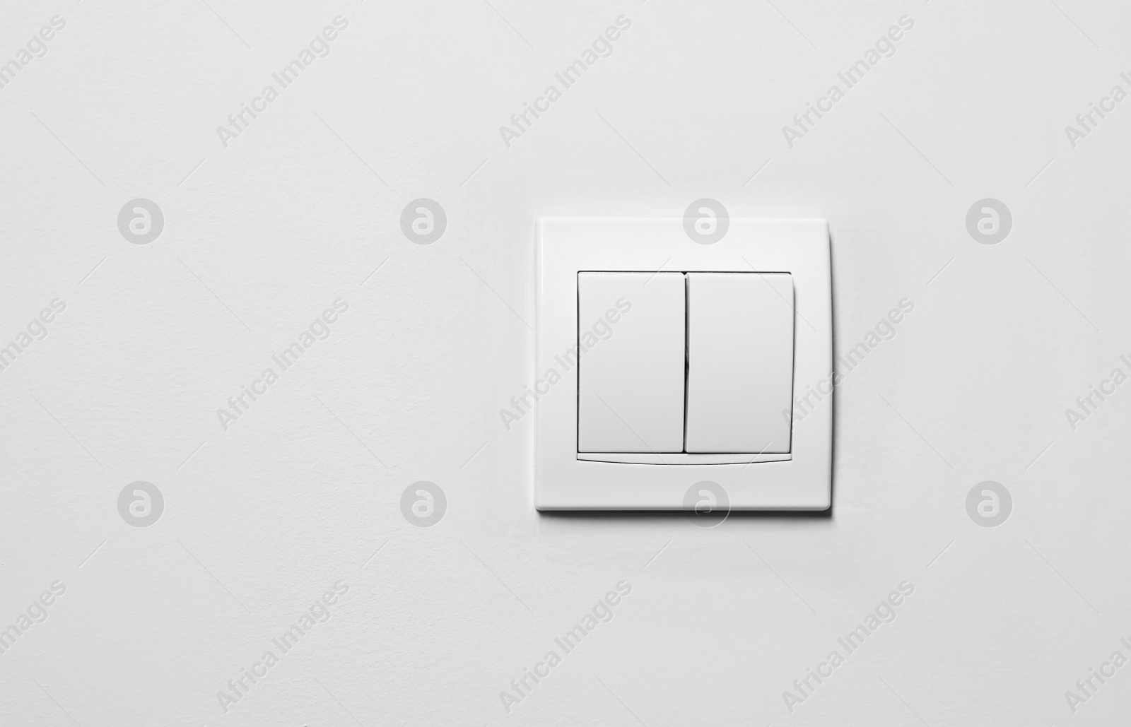 Photo of Modern plastic light switch on white wall, space for text