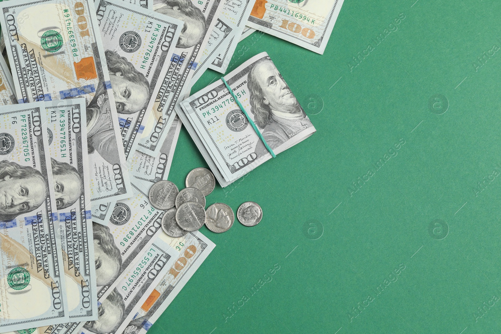 Photo of Money exchange. Dollar banknotes and coins on green background, flat lay. Space for text