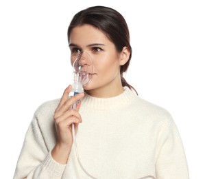 Young woman using nebulizer on white background