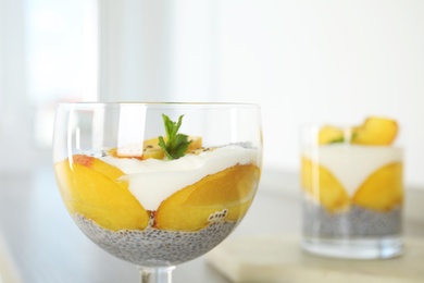 Tasty peach dessert with yogurt and chia seeds on table, closeup. Space for text