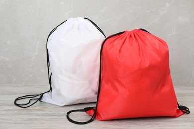 Photo of Two drawstring bags on light wooden table