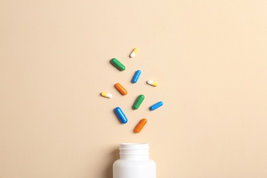 Flat lay composition with bottle and pills on color background