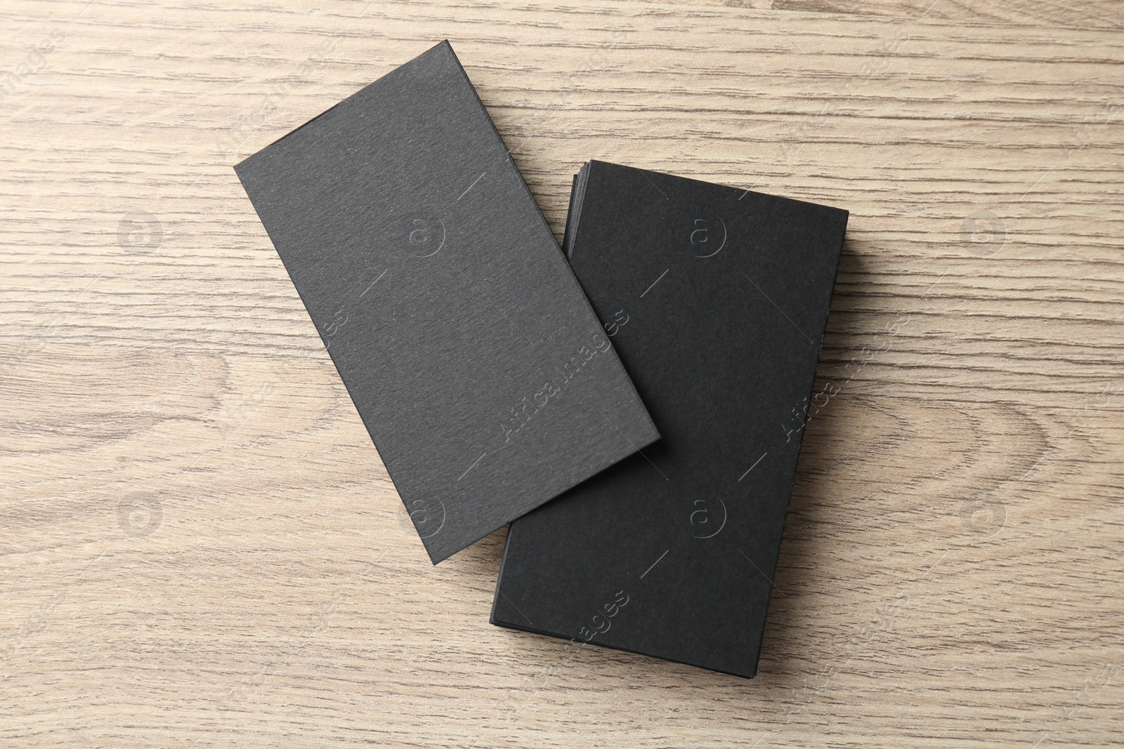 Photo of Blank black business cards on wooden table, top view. Mockup for design